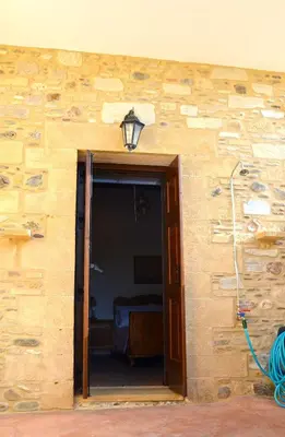 a building with an open door and a lamp at Kamara Stone House in Kissamos