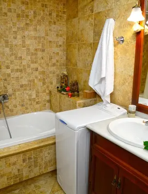 a bathroom with a tub and a sink and a tub and a toilet at Kamara Stone House in Kissamos