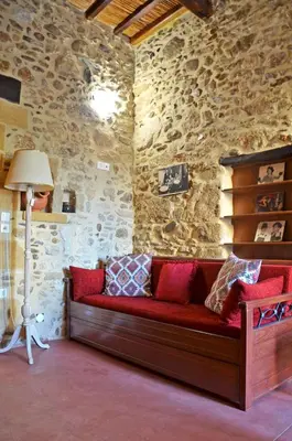 a couch in a room with a stone wall at Kamara Stone House in Kissamos