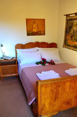 a bedroom with a wooden bed with flowers on it at Kamara Stone House in Kissamos