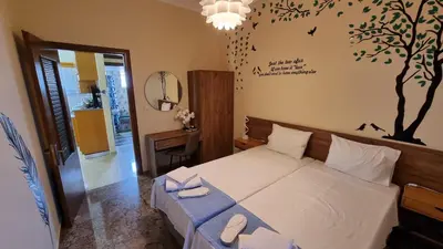 a bedroom with a bed with a tree on the wall at Enjoy Sunset in Palaiochóra