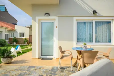 a patio with a table and chairs in front of a house at Hermes Beach Front in Stalos