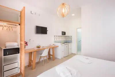 a white kitchen with a desk and a bed in a room at Hermes Beach Front in Stalos