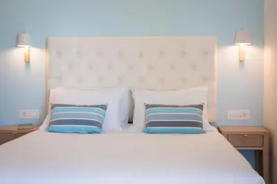 a bedroom with a large white bed with two pillows at Hermes Beach Front in Stalos
