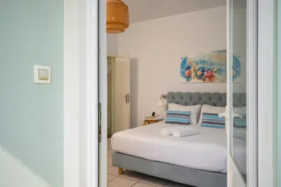 a bedroom with a bed and a painting on the wall at Hermes Beach Front in Stalos
