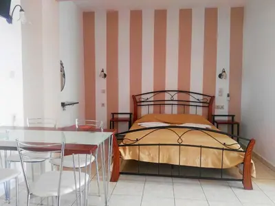 a bedroom with a bed and a table and chairs at Baladinos Apartments in Gerani Chanion