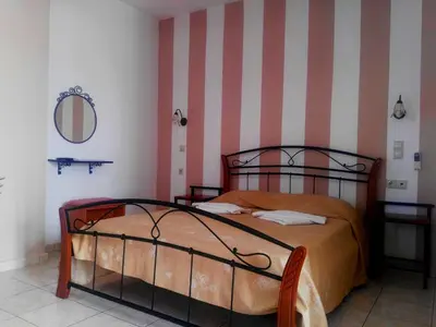 a bedroom with a bed and a striped wall at Baladinos Apartments in Gerani Chanion