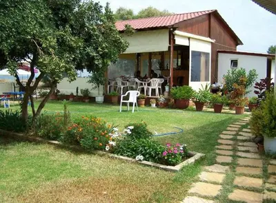 a house with a table and chairs in a yard at Baladinos Apartments in Gerani Chanion