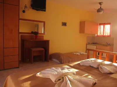 a room with a bedroom with a bed and a kitchen at Baladinos Apartments in Gerani Chanion