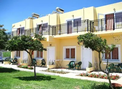 a yellow building with a balcony on top of it at Baladinos Apartments in Gerani Chanion