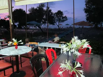 a patio with tables and chairs with a view of the beach at Baladinos Apartments in Gerani Chanion