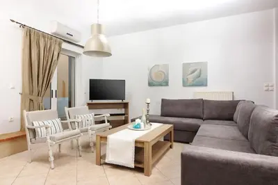 a living room with a couch and chairs and a table at Charming and Comfy House in Agia Marina Nea Kydonias