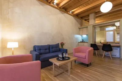 a living room with a blue couch and pink chairs at Polixeny's Suites in Chania Town