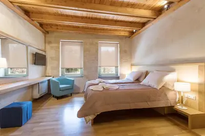 a bedroom with a bed and a blue chair at Polixeny's Suites in Chania Town