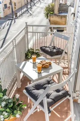 a table and chairs with a plate of food on a balcony at Nikis Apartment in Chania Town