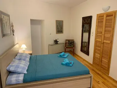 a bedroom with a bed with blue slippers on it at Tastefully Decorated One-bedroom Apartment - Chania in Chania Town