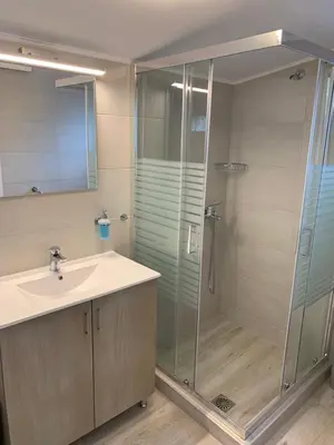 a bathroom with a glass shower and a sink at Tastefully Decorated One-bedroom Apartment - Chania in Chania Town