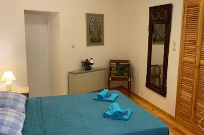 a bedroom with a bed with blue slippers on it at Tastefully Decorated One-bedroom Apartment - Chania in Chania Town