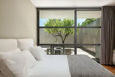 a bedroom with a white bed and a large window at Villa 7 in Perivólia