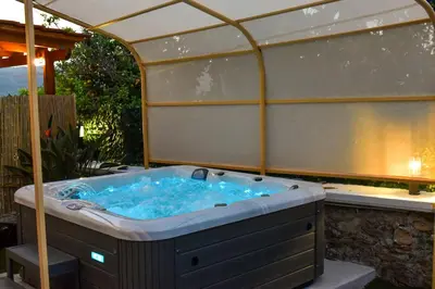 a jacuzzi tub sitting under an umbrella at George & Helen's House in Ayiá