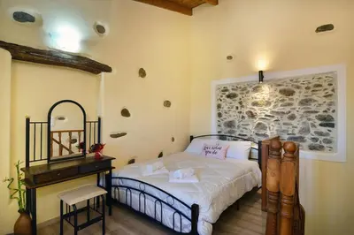 a bedroom with a bed and a desk in a room at George & Helen's House in Ayiá