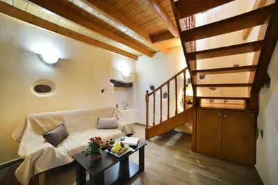 a living room with a couch and a staircase at George & Helen's House in Ayiá