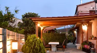 a pergola with a table and chairs on a patio at George & Helen's House in Ayiá