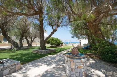 a park with trees and a stone wall at Captain's Beach Apartments in Kissamos