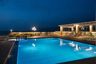 a swimming pool at night with a hotel at Captain's Beach Apartments in Kissamos