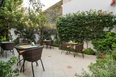 an outdoor patio with tables and chairs and plants at Manto Studios in Palaiochóra