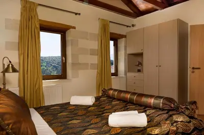 a bedroom with a large bed and a window at Olga's Filoxenia - Villa Aladanos-private pool and heated jacuzzi in Makhairoí