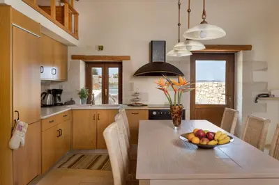 a kitchen with a table with a bowl of fruit on it at Olga's Filoxenia - Villa Aladanos-private pool and heated jacuzzi in Makhairoí