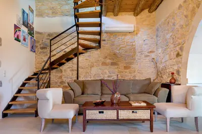 a living room with a couch and a staircase at Olga's Filoxenia - Villa Aladanos-private pool and heated jacuzzi in Makhairoí