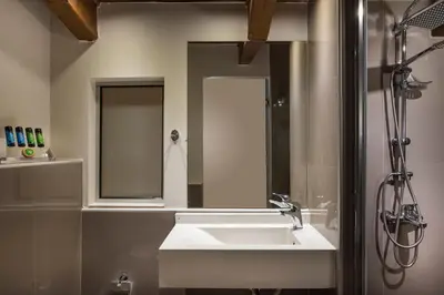 a bathroom with a white sink and a mirror at Elotis Suites in Agia Marina Nea Kydonias