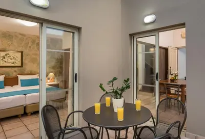 a room with a table and chairs and a bedroom at Elotis Suites in Agia Marina Nea Kydonias