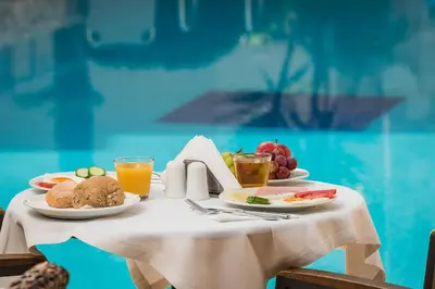 a table with plates of food and drinks on it at Elotis Suites in Agia Marina Nea Kydonias