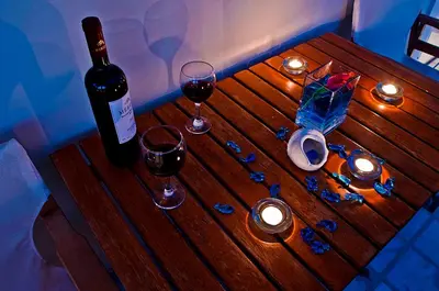 a wooden table with two glasses of wine and candles at Sea Breeze in Kalamaki Chanion