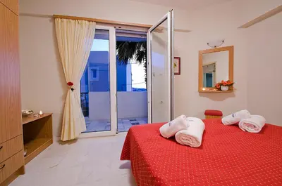 a bedroom with a red bed with towels on it at Sea Breeze in Kalamaki Chanion
