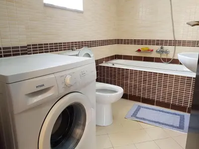 a bathroom with a washing machine and a toilet at Ilia's Apt in Chania in Chania Town