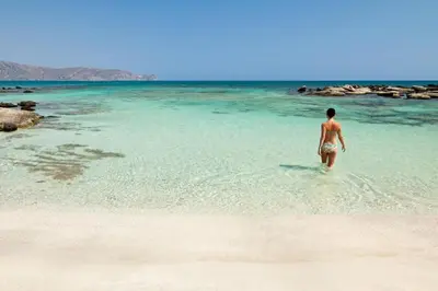 a person walking in the water on a beach at Ilia's Apt in Chania in Chania Town