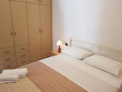 a bedroom with a white bed and a night stand at Ilia's Apt in Chania in Chania Town