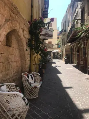 an alley with wicker chairs on the side of a building at Lito Rooms in Chania Town