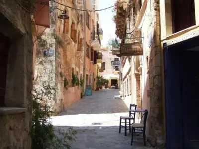 an alley with two chairs in an alley between buildings at Lito Rooms in Chania Town