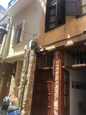 a building with a wooden door on a street at Lito Rooms in Chania Town