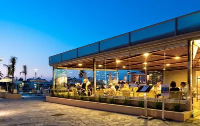 a restaurant with people sitting inside of it at night at Porto Platanias Village Resort in Plataniás