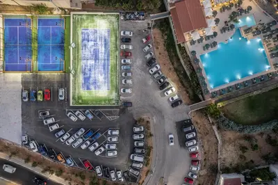an overhead view of a parking lot with cars and a pool at Porto Platanias Village Resort in Plataniás