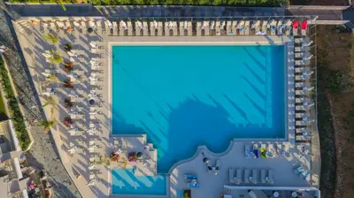 an overhead view of a large swimming pool with a group of people at Porto Platanias Village Resort in Plataniás
