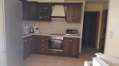 a kitchen with wooden cabinets and a microwave at Douliana Villas in Douliana