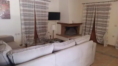 a living room with a white couch and a fireplace at Douliana Villas in Douliana