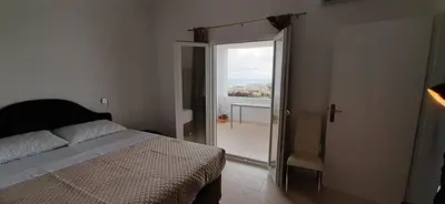 a bedroom with a bed and a door to a balcony at Thea Apartment in Agia Marina Nea Kydonias